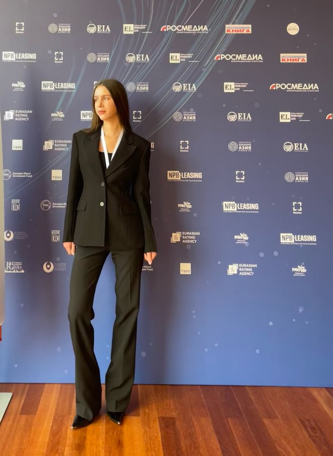 Mariia Miroshnik at a press event backdrop after a science conference
